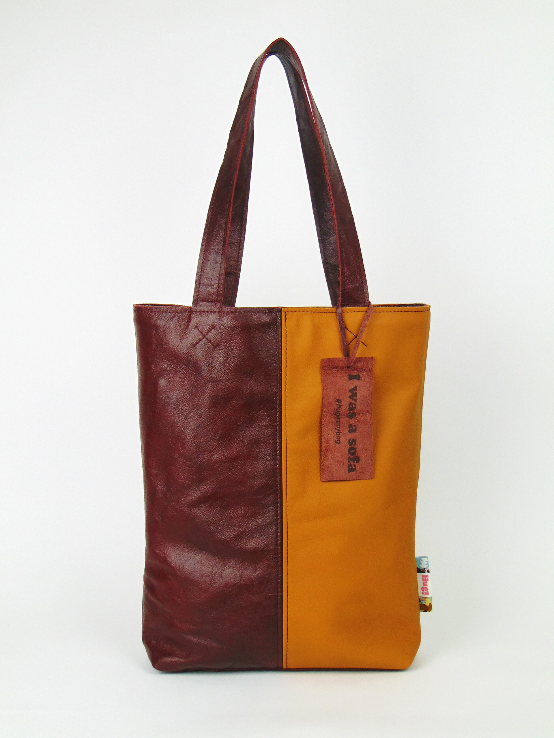 Product image of the shopper named Disco Inferno. This shopper is made from recycled leather in a colour combination of redbrown and yellow.