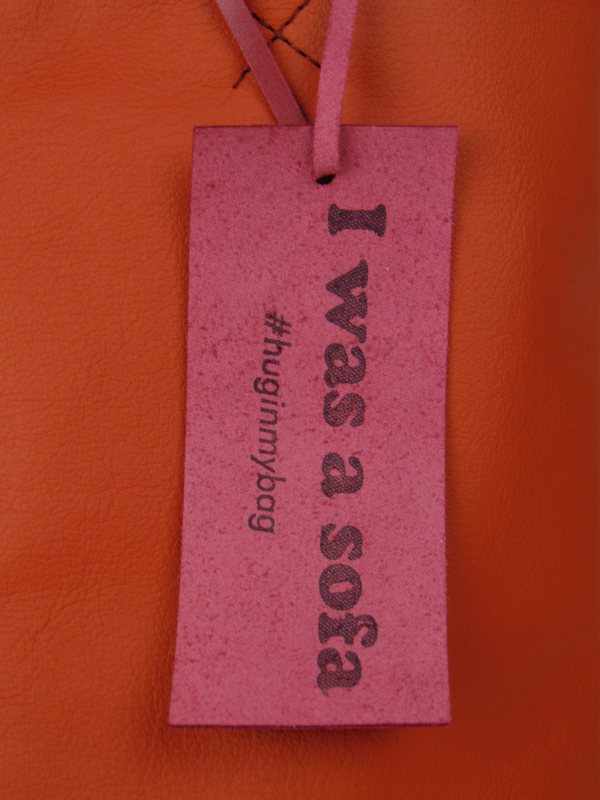 Close up picture of the leather label on the bag with the text: I was a sofa #huginmybag